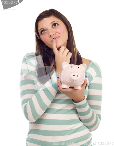 Image of Ethnic Female Daydreaming and Holding Piggy Bank on White