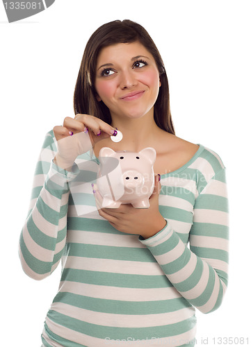 Image of Ethnic Female Putting Coin Into Piggy Bank on White
