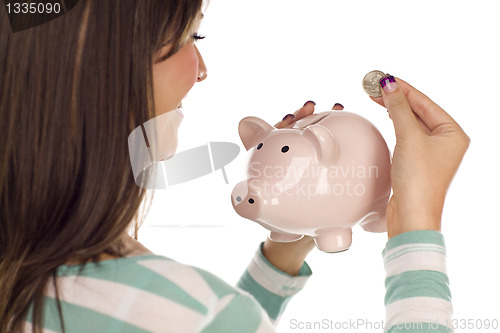 Image of Ethnic Female Putting Coin Into Piggy Bank on White