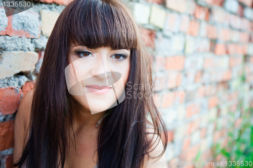 Image of beautiful girl against old brick wall