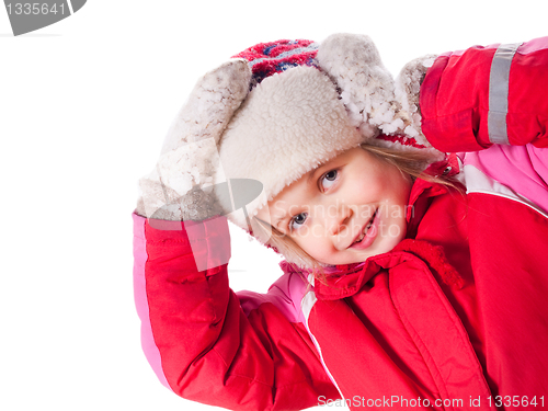 Image of The laughing girl wearing red overalls and mittens with snow