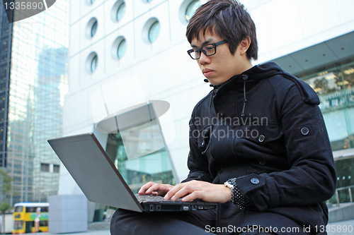 Image of man using computer outdoor 