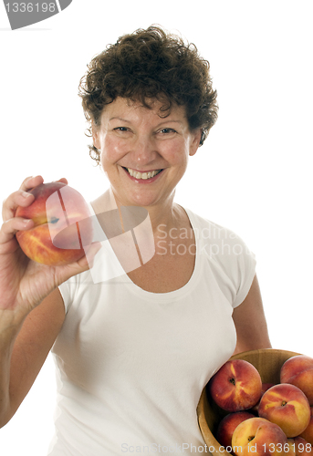 Image of excited middle age senior woman with fresh peaches fruit