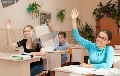 Image of schoolgirl in class raised their hands