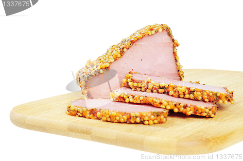 Image of Piece of a ham with spices on a wooden board