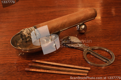 Image of Cigar on a stand with matches&cutters