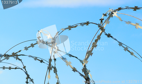 Image of Barbed wire on blue sky.