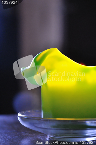 Image of Molten green candle against a dark background