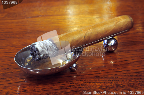 Image of Cigar on a stand on a wooden background