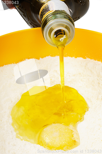 Image of Oil flowing  to  the broken egg in the flour