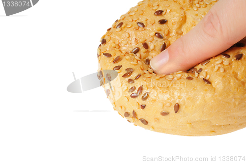 Image of Bun, topped with sesame seeds pressed with finger