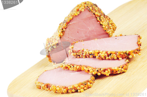 Image of Piece of a ham with spices on a wooden board