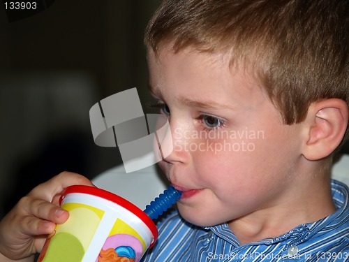 Image of boy at restaurant drinking through a straw