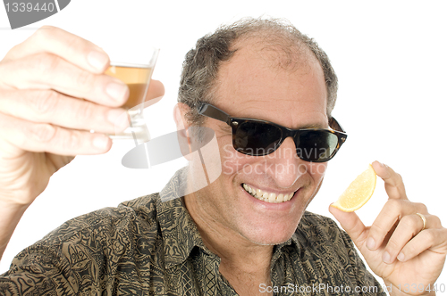 Image of middle age senior tourist male sun glasses  drinking tequila sho