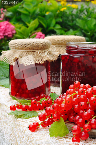 Image of Jars of homemade red currant jam with fresh fruits