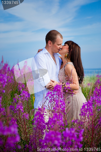 Image of Romantic kiss among purple flowers