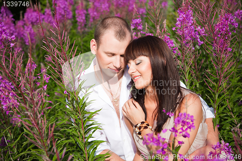 Image of Romantic couple among purple flowers