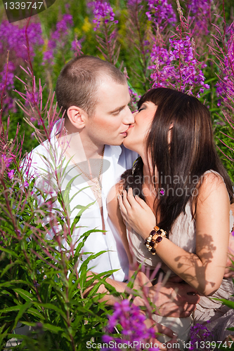 Image of Romantic kiss among purple flowers