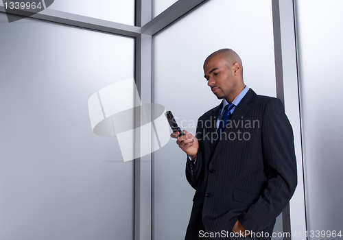 Image of Businessman sending a message with his cell phone