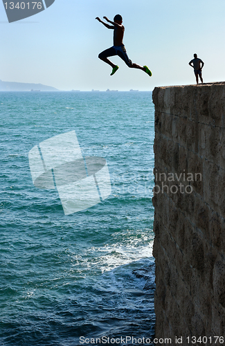Image of Teens, jumping into the sea.