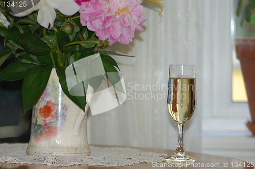 Image of Glass of white wine and flowers