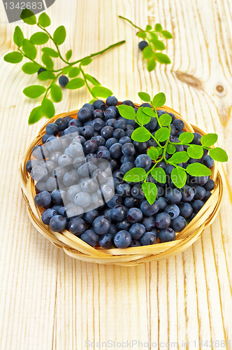 Image of Blueberries in a wicker tray on a blackboard