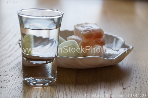 Image of glass with vodka and a small dish of lard and onions