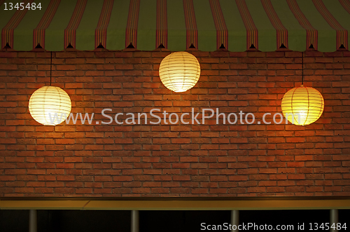 Image of Brick wall with three illuminated lamps