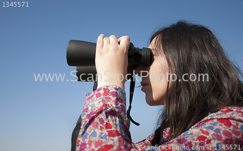 Image of Young woman using binoculars 