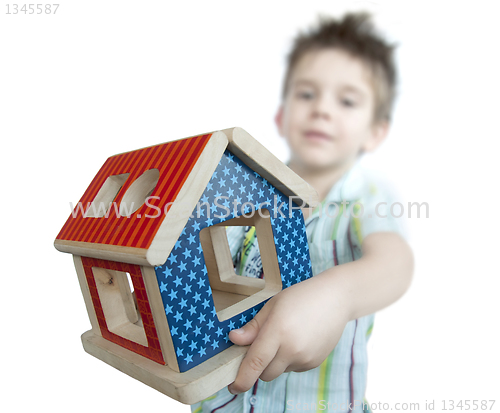 Image of Boy presenting wood colorful house toy 