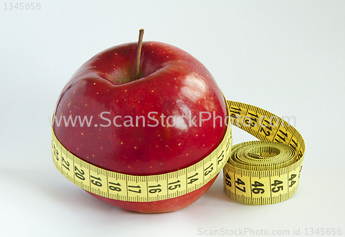 Image of Yellow tape Measure with red Apple