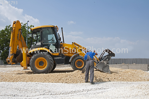 Image of Worker and gravel excavator