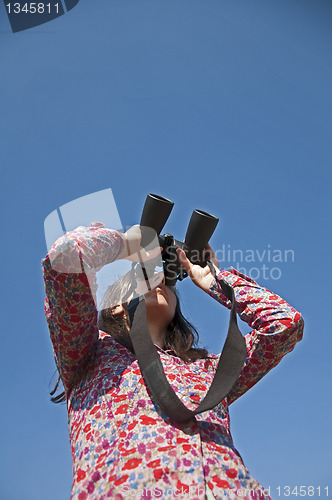 Image of Young woman using binoculars 