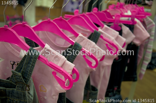 Image of Clothes hang on hangers in shop
