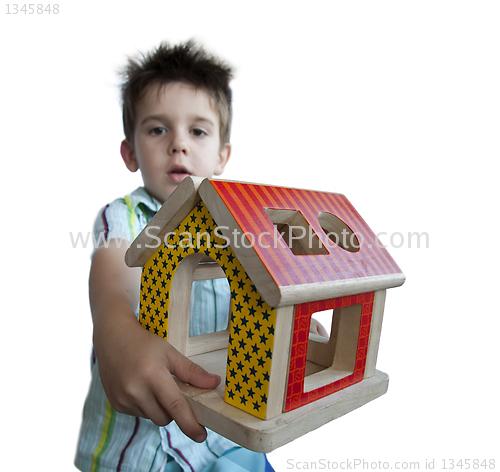 Image of Boy presenting wood colorful house toy 