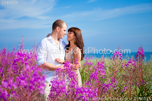 Image of Romace among purple flowers near blue sea