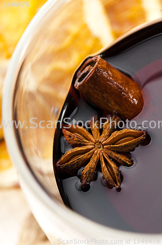 Image of Mulled wine with slice of orange and spices.