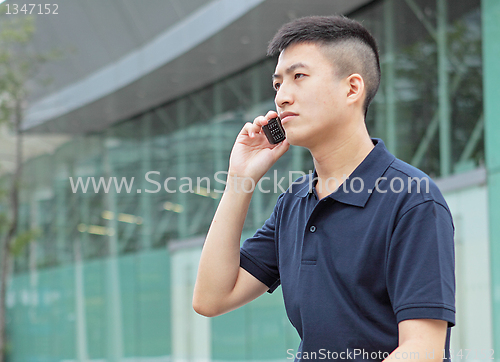 Image of young man talking phone outdoor