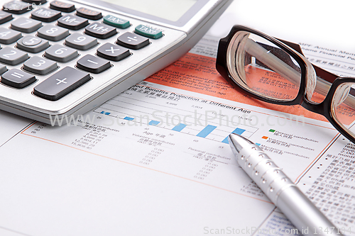 Image of Stock chart with calculator,pen and eyeglasses 