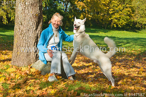 Image of The woman with a dog in autumn park