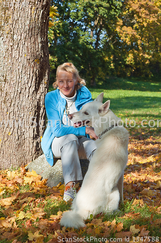 Image of The woman with a dog in autumn park