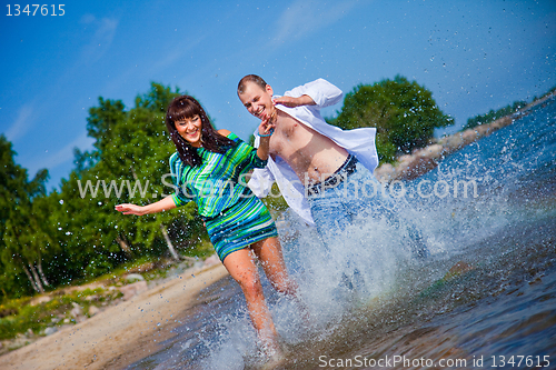 Image of Enamored couple running along the coast of sea