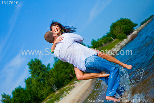 Image of Enamored couple embracing on sunny beach