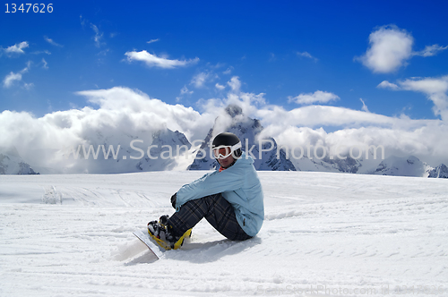 Image of Snowboarder resting on the ski slope