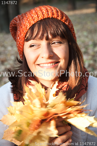 Image of woman with autumn orange leaves