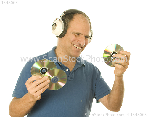 Image of senior man listening to music cd discs with vintage head phones 