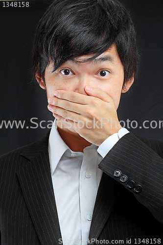 Image of scared adult man with hand covering mouth 
