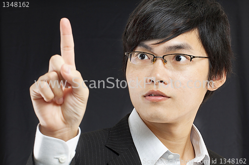 Image of young business man in a suit pointing with his finger