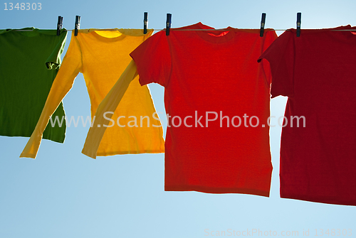 Image of Bright multi-colored clothes drying in the wind