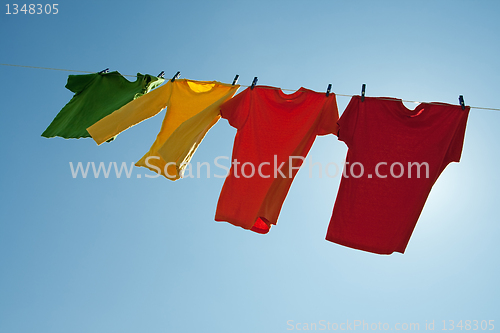 Image of Colorful clothes hanging to dry in the blue sky